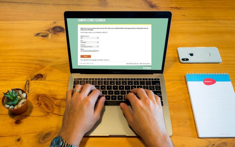 Campus store feedback Hands typing on laptop with survey on screen titled "Campus Store Feedback"