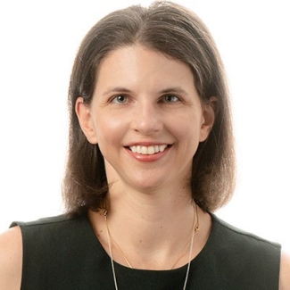 Smiling woman with shoulder-length hair and a sleeveless dress.