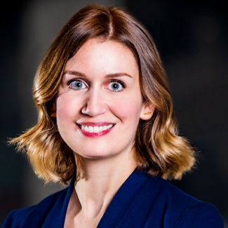 Young, smiling woman with shoulder-length, blonde hair and a blue jacket.