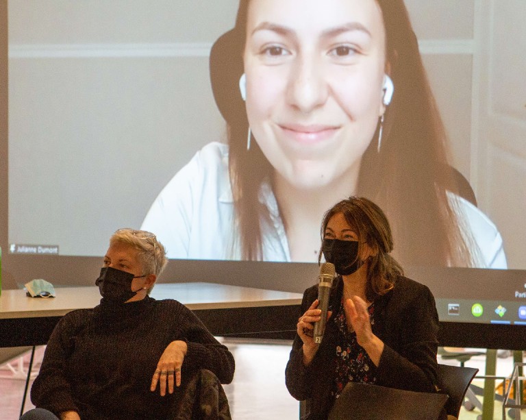 Livestream video projection of smiling young woman with brown hair