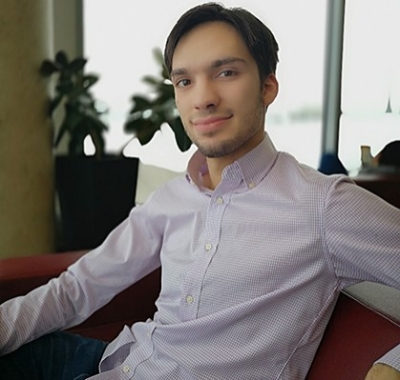 Young smiling man with short, dark hair, wearing a dress shirt.