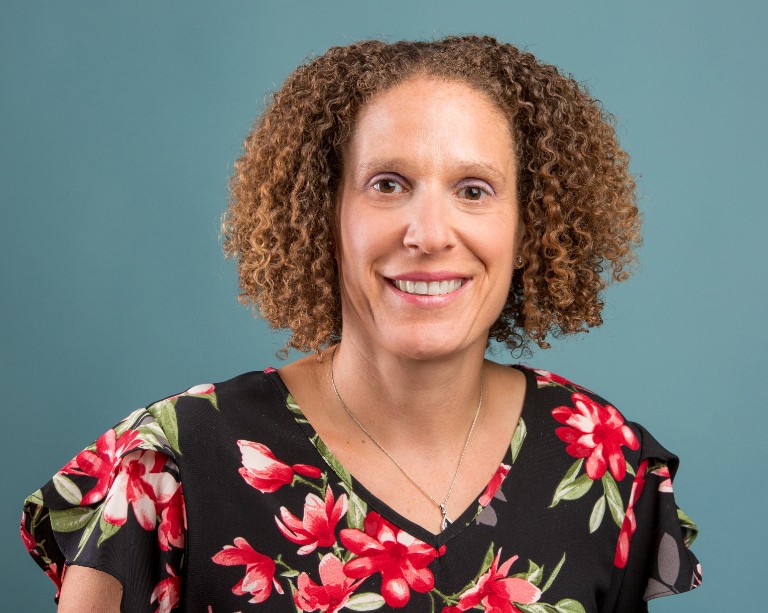 Headshot of smiling woman wearing floral shirt