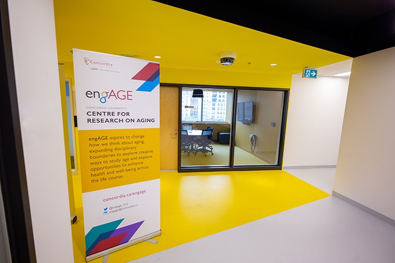 A building interior with a placard placed in a corridor with heading, "EngAGE."