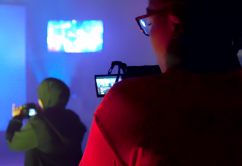 Still from the documentary essay <em>Stepping Into Halka.</em> | Courtesy of Veronica Mockler Two people seen from the back carrying video cameras.