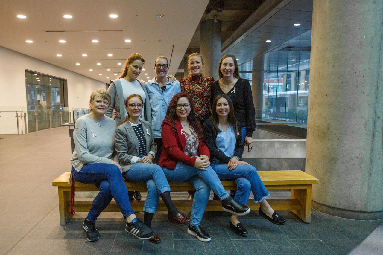 8 Co-op Institute employees wearing pink ribbons and denim jeans