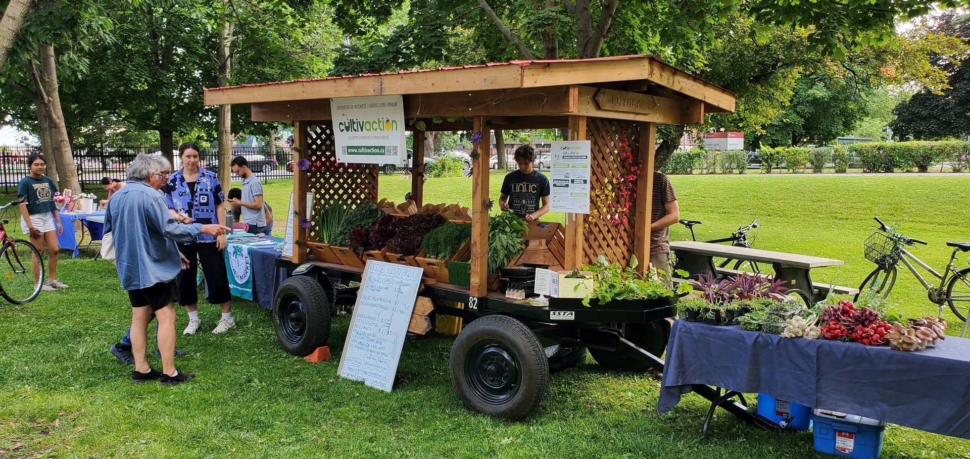 Crowd of people standing around a vendor's station at a farmers market