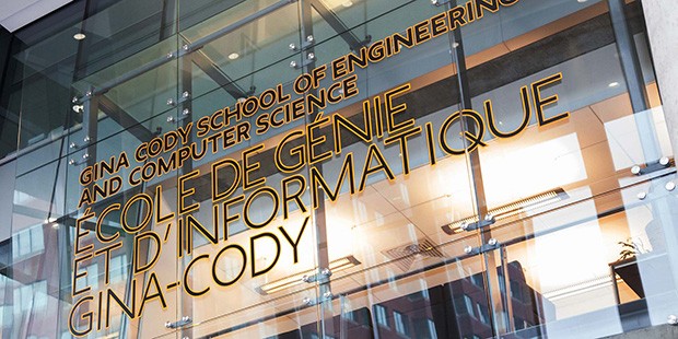 Curtain window of a building, with the words, "Gina Cody School of Engineering and Computer Science" printed on the glass in black and yellow font.