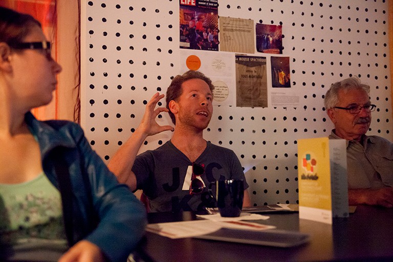 Three people sitting at a cafe table and having a discussion