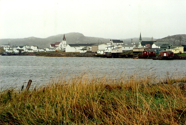 Archival photo of a river and a village beyond