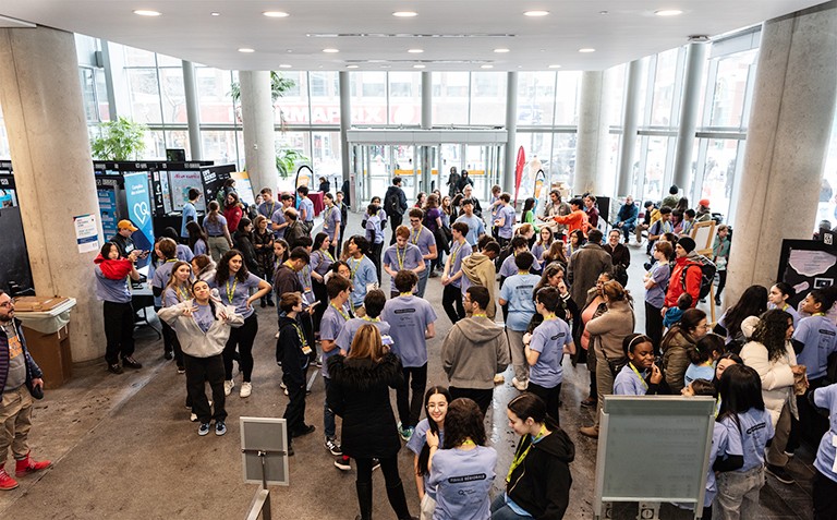 A crowd of young people in a large interior atrium.