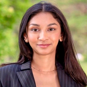 Smiling young woman with long, dark hair, wearing a striped blazer