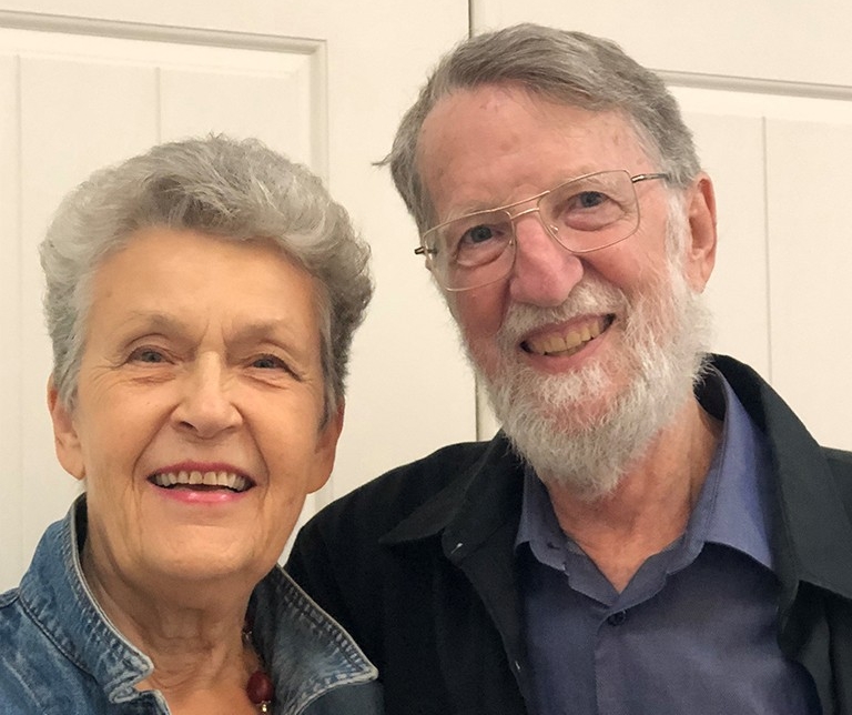 William Reimer and Frances Shaver Image of a husband and wife standing side by side in front of white doors, smiling