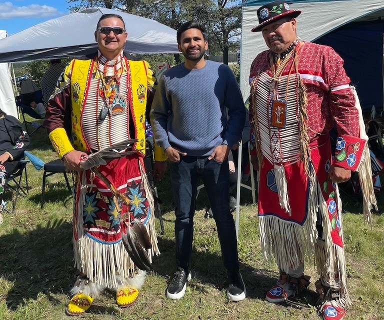 Muhammad Ahsan with Cree Elders at the Pow Wow in Chisasibi A young man stands with two Cree elders in traditional dress at a pow wow.