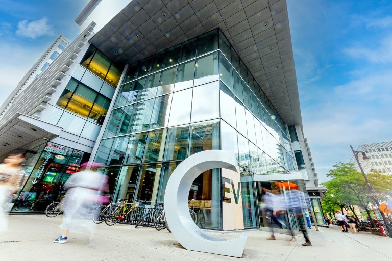 Safety and respect on campus: week of October 7 to 11 A modern glass building with a large "C" sculpture in front, surrounded by bicycles and people walking past.