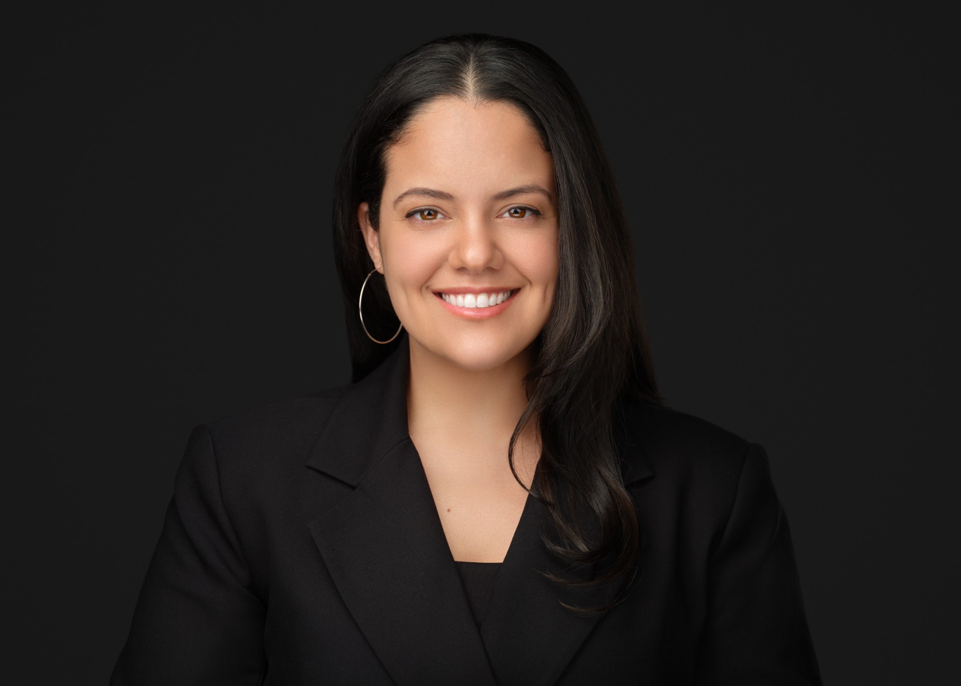 Smiling woman, dark hair, black suit