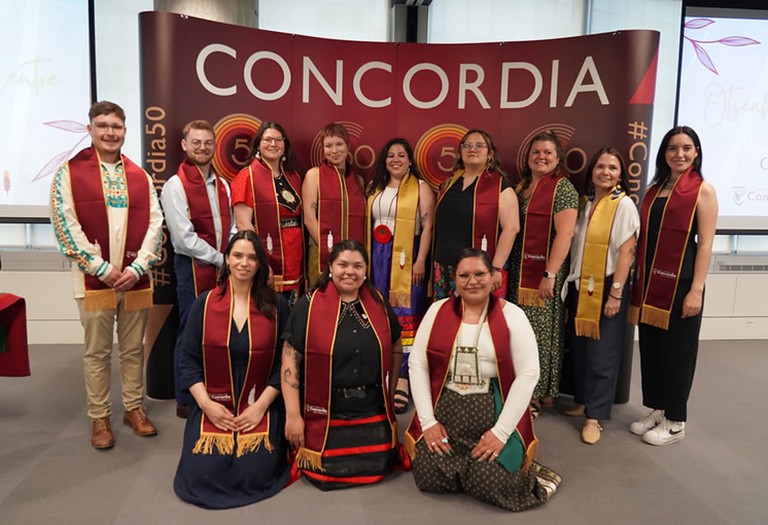 A group of people, all wearing convocation sashes.
