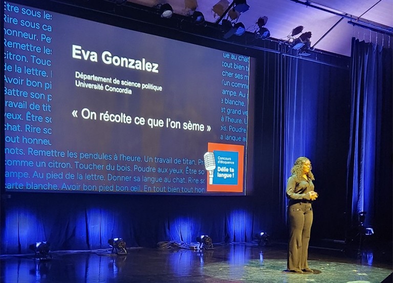 A young woman giving a presentation on a stage