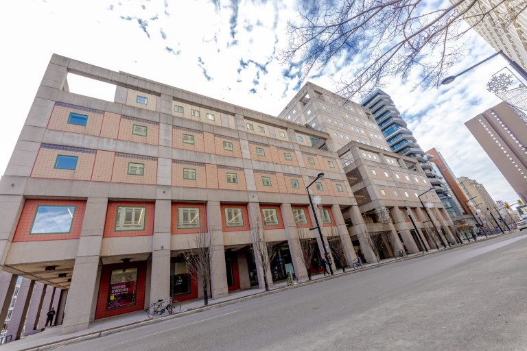 Exterior view of the J.W. McConnell Building on De Maisonneuve Boulevard West, with pedestrians and surrounding campus buildings visible.