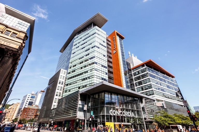 Concordia’s Engineering, Computer Science and Visual Arts Integrated Complex (EV) on the Sir George Williams Campus, viewed from the street with pedestrians and traffic at the intersection.