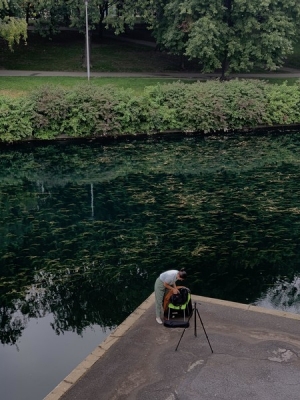 Zoé Bailly-Stetson captures sound on a dock near a lake.