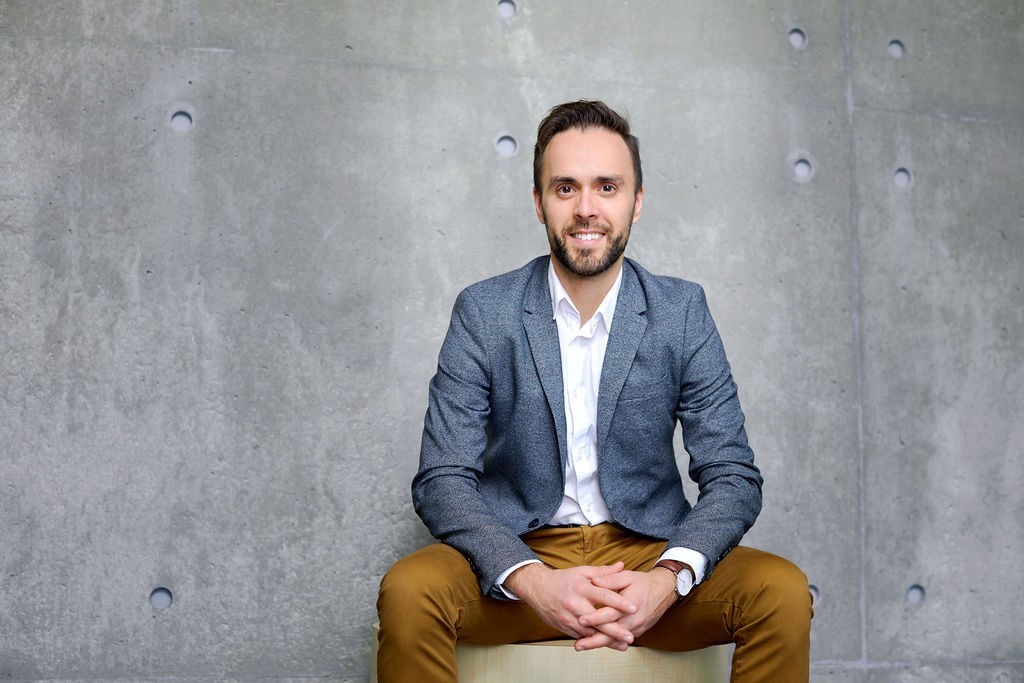 Étienne Cantin-Bellemare sits, facing the camera, wearing a blue jacket