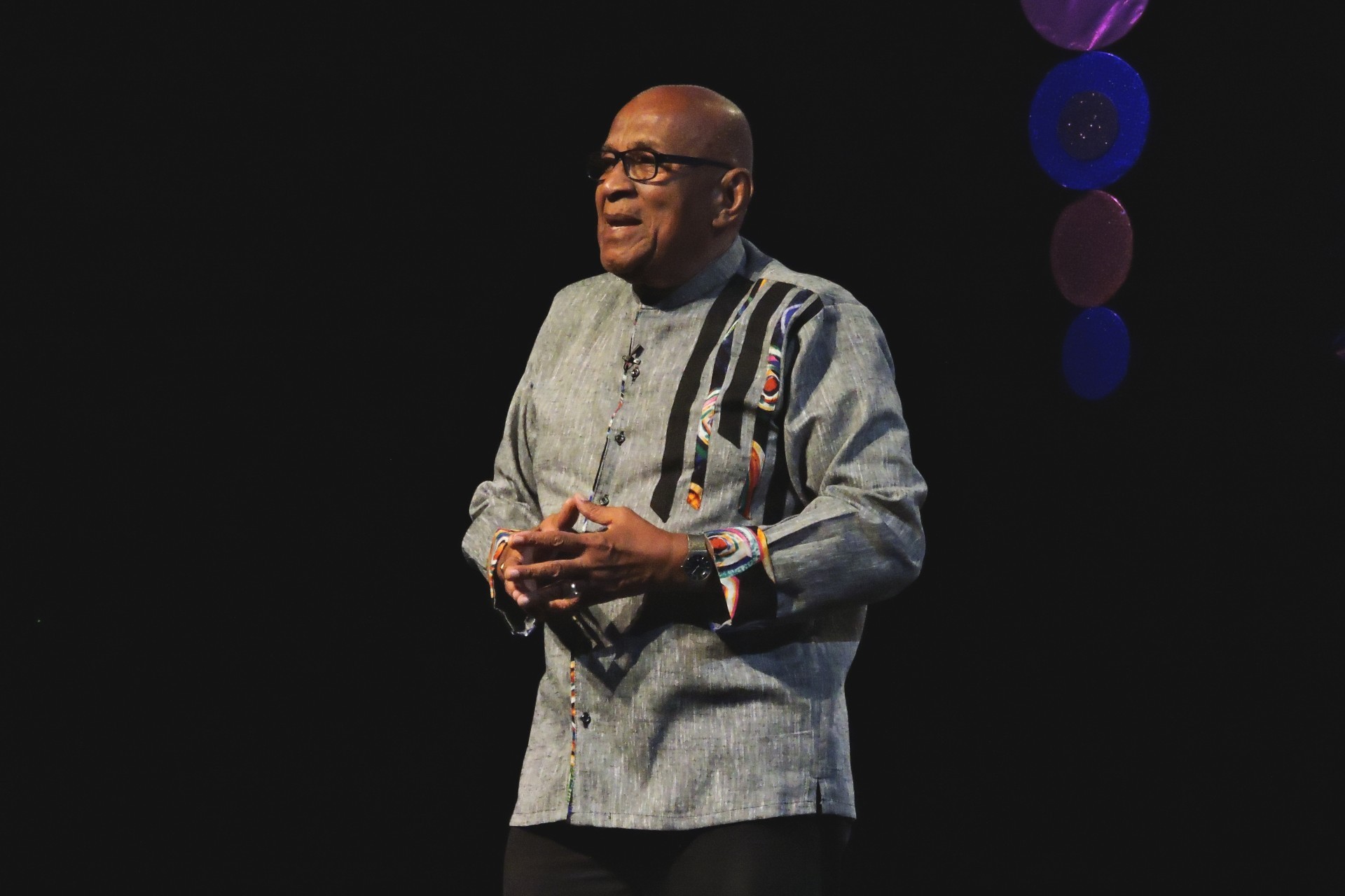 Keens-Douglas stands on a stage, addressing an audience