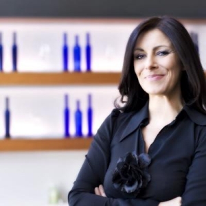 Manon Gauthier wears a black blouse, smiling, with her arms folded.