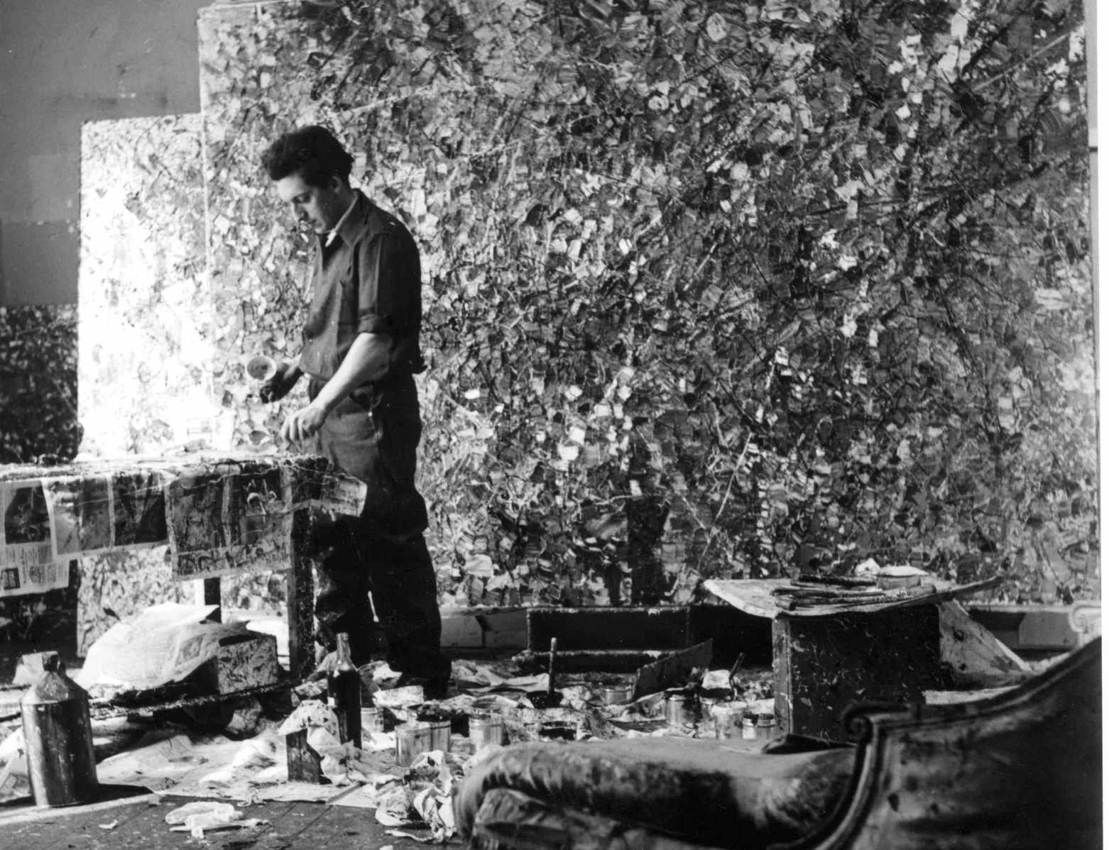 Jean Paul Riopelle black and white portrait of Riopelle in front of an abstract painting