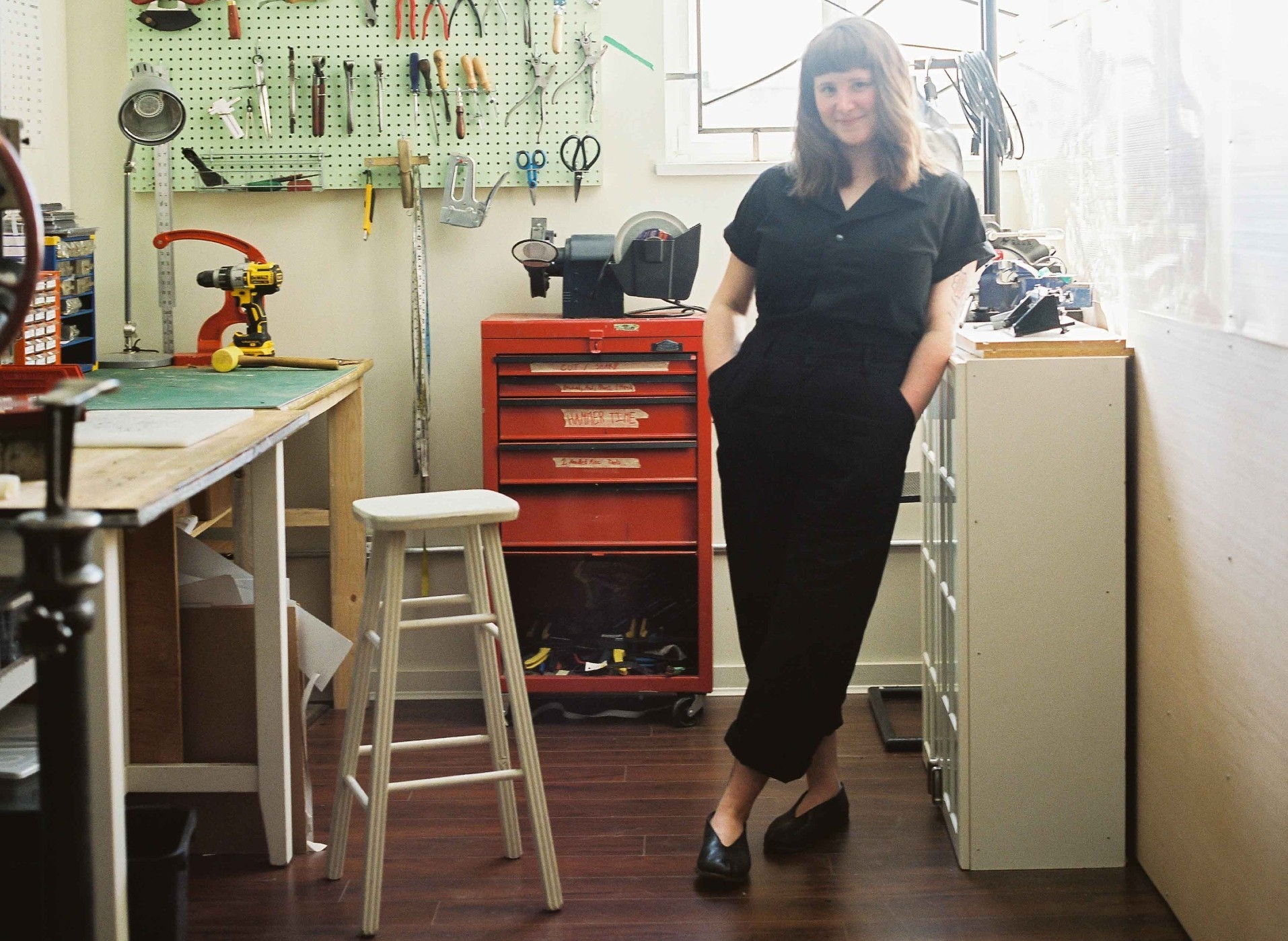 Tess Gobeil, standing in her cobbler studio