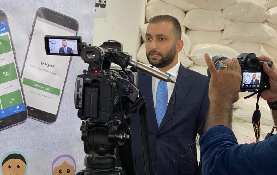 Bashar Alhammami, wearing a suit, faces a TV camera