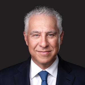 close-up of Jeffrey Kobernick, wearing a dark suit and blue tie