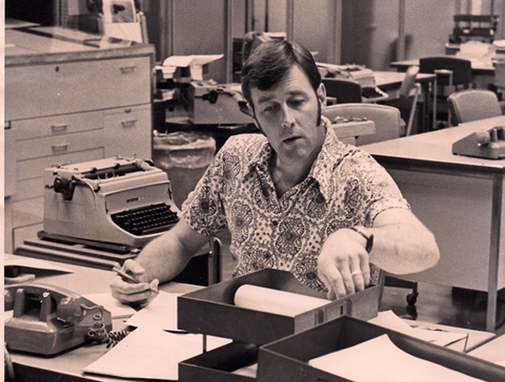 vintage black and white photo of Russ Peden at his desk at the Montreal Star