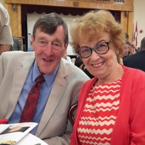 Russell Peden and Barbara Black sit together, smiling at the camera