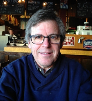 Man wearing navy blue sweater and dark-rimmed glasses