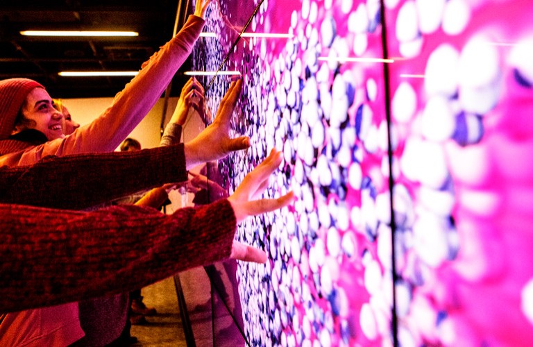 Students touch a screen in the Visualization Studio in the Webster Library.