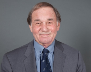 James O'Reilly where as suit in front of a grey background and smiles for the camera.