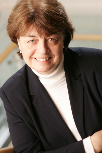 Headshot of woman with brown hair and black blazer