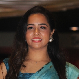 Fauzia has long dark hair and wears a turquoise sari top