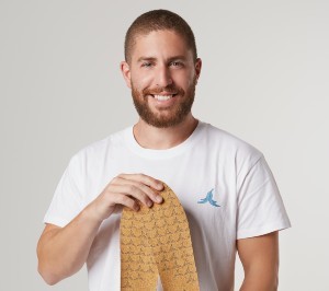 A man with short hair and a beard poses with a pair of insoles