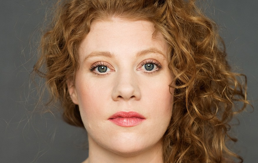 Portrait of a young woman with curly red hair