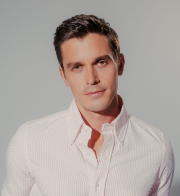 Portrait of a man with dark hair wearing a white shirt