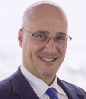 portrait of a man wearing a suit and tie, with glasses