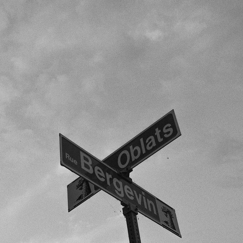 Seen from below are two sign post that say Rue Bergevin and Oblats