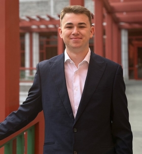 Aiden Cyr wears a dark blue blazer over a dress shirt