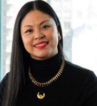 Portrait of a woman wearing black turtleneck and gold pendant