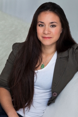 Portrait of a woman wearing a white T-shirt with a khaki blazer and jade pendant