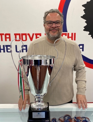 Man wearing glasses pictured with large trophy cup