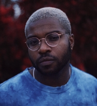Portrait of a man with short hair wearing glasses and blue T-shirt