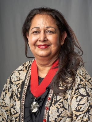 Woman wearing patterned gold, silver and black floral jacket wears a medal of the Ordre de Montréal around her neck