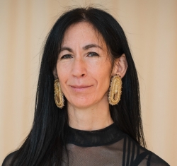 Portrait of a woman with long black hair, black shirt and beaded earrings